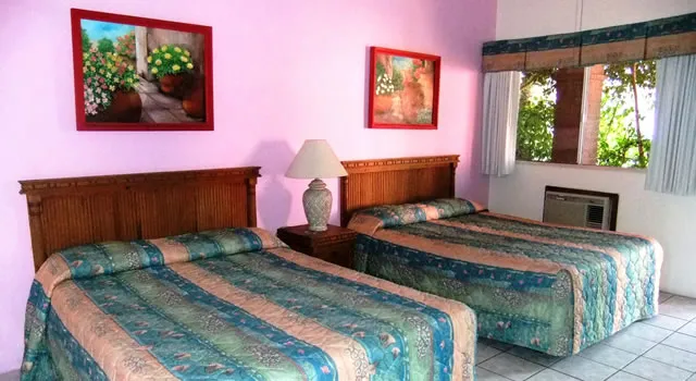 Guest room with two queen beds and pink walls