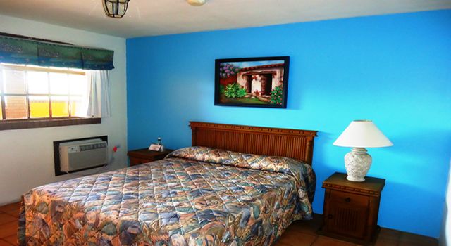 Guest room with a queen bed and blue walls