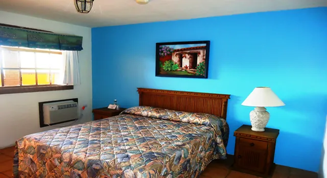 Guest room with a queen bed and blue walls