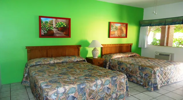 Guest room with two queen beds and green walls